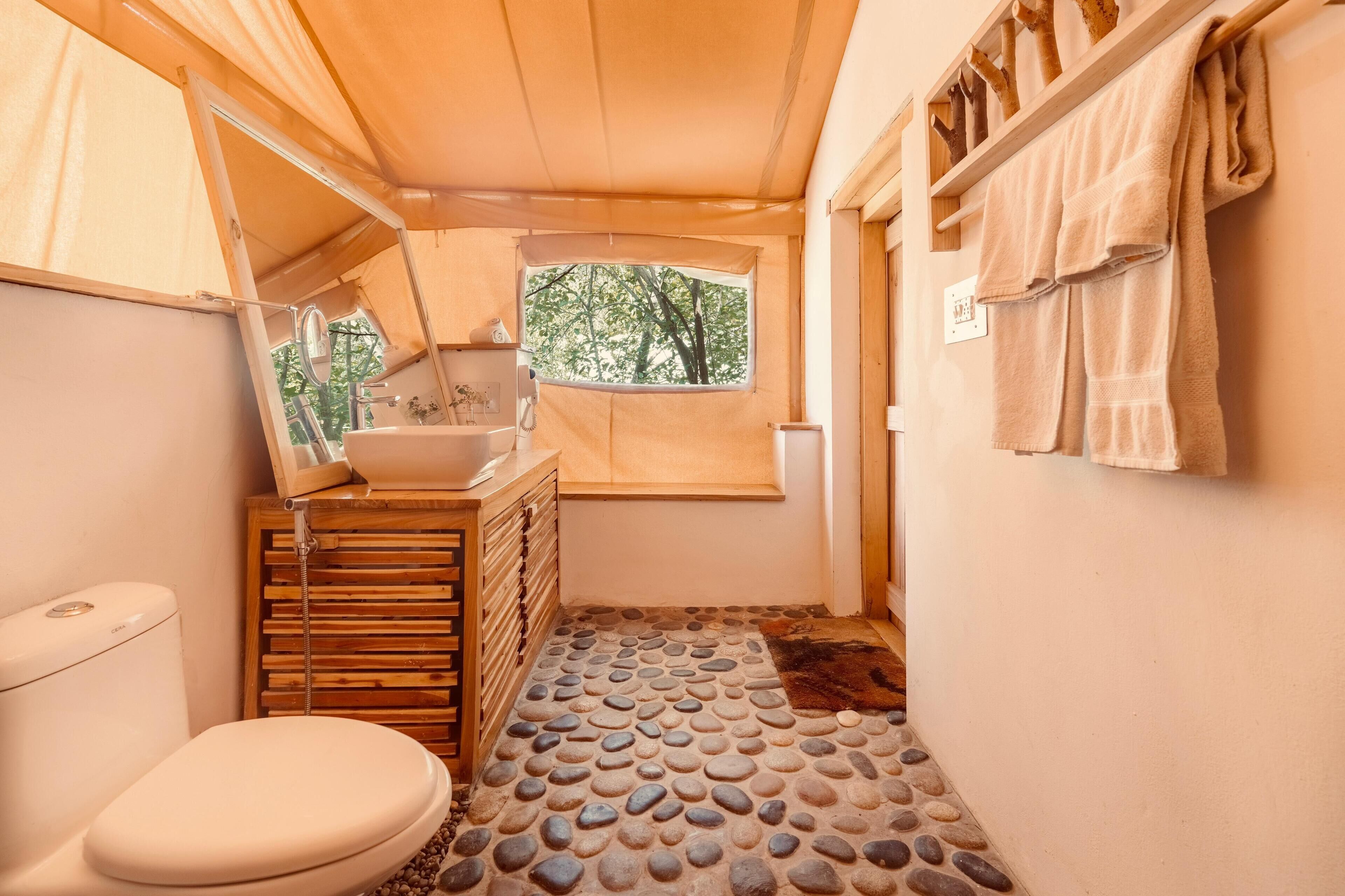 Een kleine badkamer met toilet, wastafel en een houten opbergmeubel.