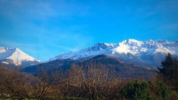 Un paisaje montañoso con picos nevados y un cielo azul despejado.