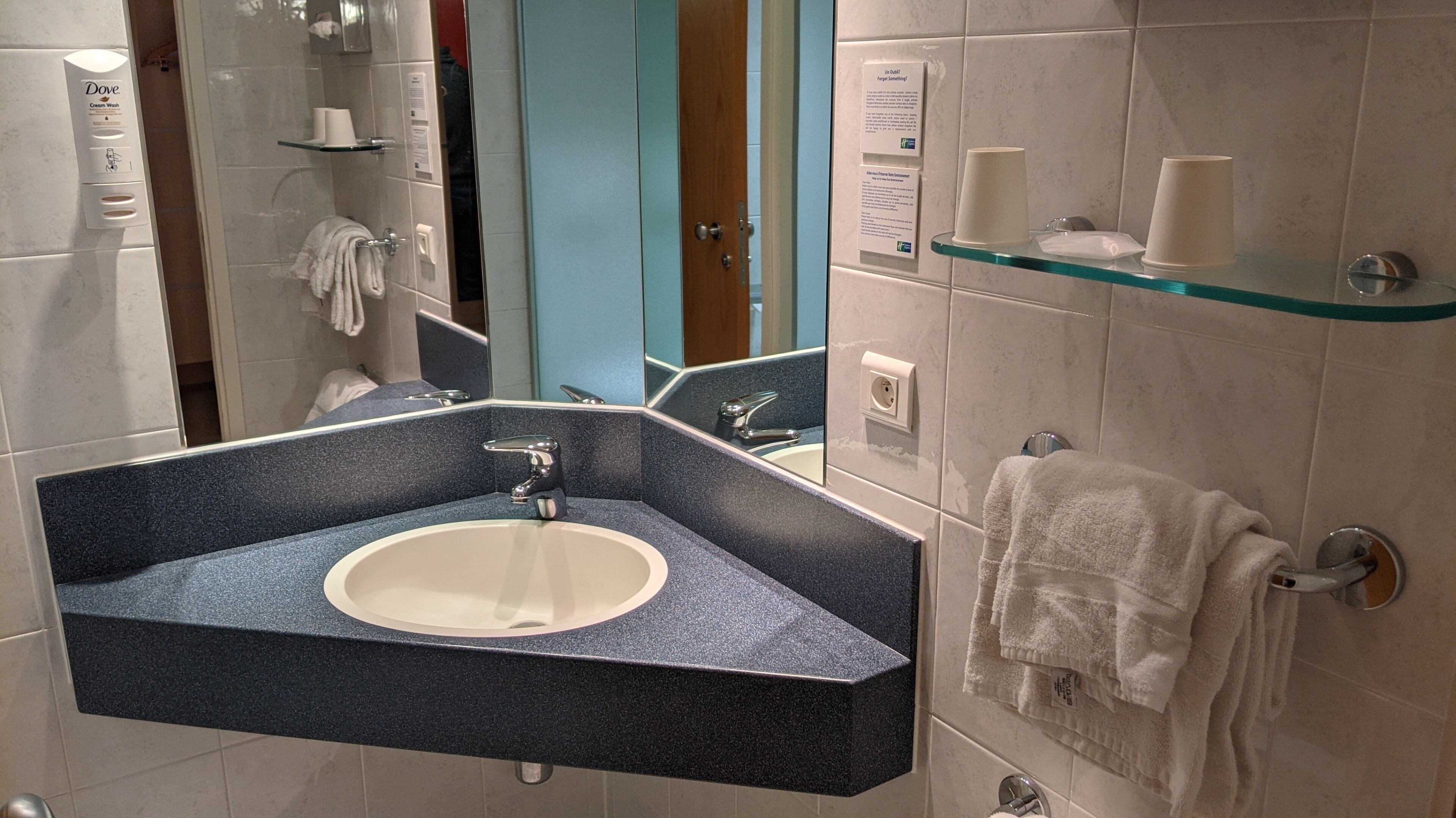 Une salle de bain équipée d’un lavabo, d’un miroir et d’un porte-serviettes.