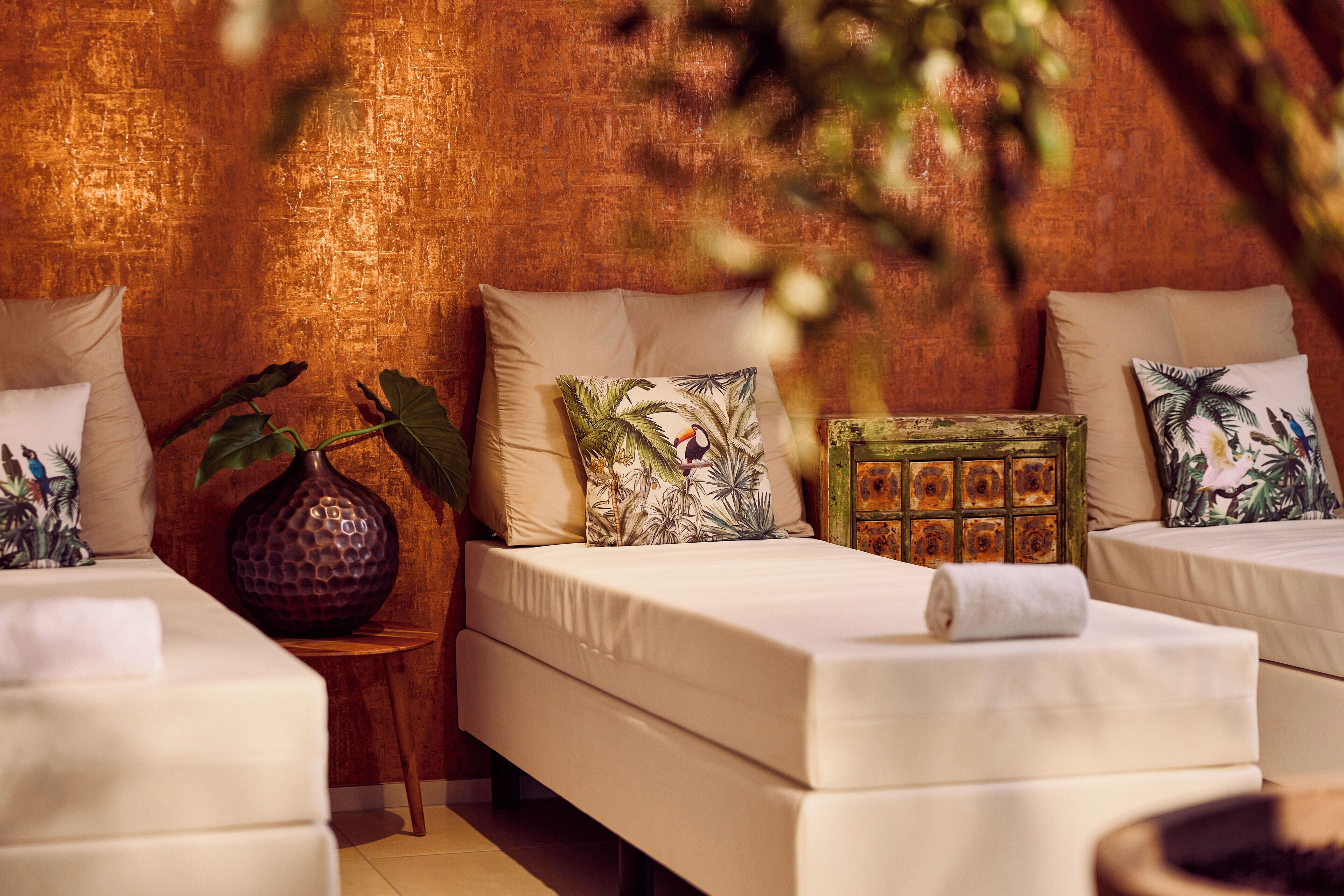 A hotel room with two beds, a small table, and a decorative vase.