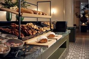 Un bufé con una variedad de productos de panadería y repostería.