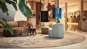 A modern lobby with a curved seating area, a reception desk, and a digital directory.