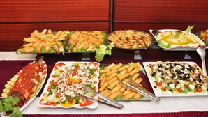 Un tavolo del buffet con diversi piatti, tra cui pesce, insalate e antipasti.