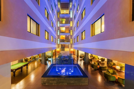 A hotel lobby with a central water feature, multiple floors, and seating areas.. Classic Grande Imphal - A Member of Radisson Individuals