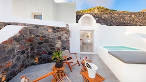Terraza en la azotea con paredes de piedra, piscina, muebles de mimbre y vistas al paisaje.