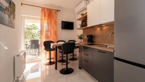 Una cocina moderna con comedor, un televisor sobre la encimera y vistas al exterior.