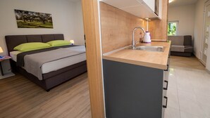 A modern bedroom with a bed, bedside table, and a painting on the wall. - Apartment Šerbečić 4 with sea view for 4 persons on the island of Krk (Malinska)