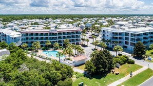 A resort with multiple buildings, a swimming pool, and surrounding greenery.