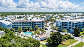 Un resort con varias edificaciones, una piscina y follaje circundante.