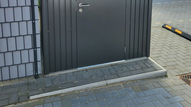 Een donkere metalen deur met een sleutelgat en een handgreep.