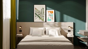 A hotel room with a large bed, two bedside tables, a nightstand, a window with curtains, and two framed cityscape artworks on the wall. - Spark by Hilton Milan Linate Airport (Segrate)