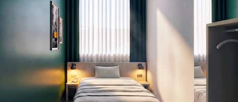 Une chambre d’hôtel avec un lit, des lampes de chevet, une table de nuit, un tableau encadré au mur et une fenêtre avec des rideaux.