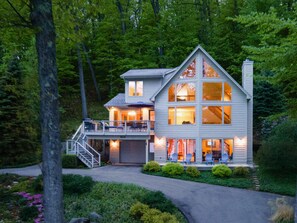 A two-story house with a balcony, a covered porch, and a driveway.