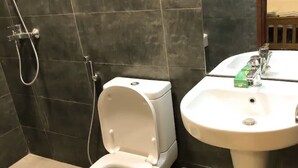 A bathroom with a toilet, a sink, and a shower. - Mapembeani (Zanzibar)