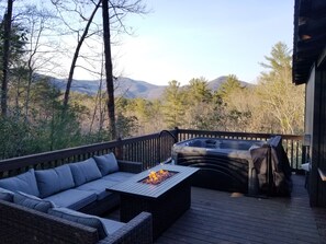 A deck with a fire pit table, a sofa, and a grill. - Swann's View - Remodeled cabin with amazing mountain views! (Sautee Nacoochee)