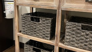 A wooden cabinet with three wicker baskets and a Wi-Fi sign above it. - NEW, NEW, NEW! Wabasha Downtown Studio 113 Pembroke Ave. #103 (Wabasha)