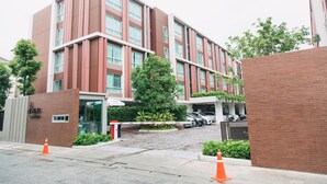 Um hotel de vários andares com design moderno, destacando fachada de tijolos e grandes janelas.