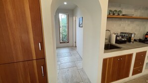 A modern kitchen with wooden cabinets, a built-in sink, and a tiled backsplash. - Charming, Private, Poolside Cottage (Glendale)