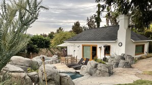 A house with a patio, outdoor seating, a swimming pool, and a rock garden. - Charming, Private, Poolside Cottage (Glendale)