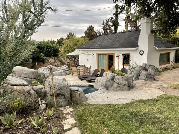 Une maison dotée d’un patio, d’un espace salon extérieur, d’une piscine et d’un jardin de rocaille.