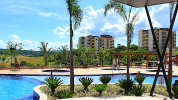 Una piscina al aire libre, sillones reclinables de piscina