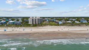 A coastal hotel with multiple buildings, a sandy beach, and the ocean. - The Beach Hive: Ocean view condo in the heart of Emerald Isle (Emerald Isle)