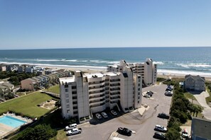 A high-rise hotel with multiple balconies overlooking the beach.