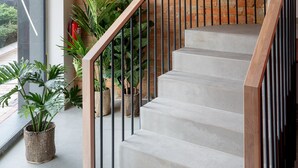Un escalier avec un mur en briques, des rampes en métal et des plantes en pot.