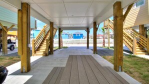 A covered outdoor area with wooden stairs leading to a building.
