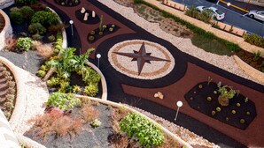 Una zona enjardinada amb un disseny circular, un dibuix estel·lar i diferents plantes.