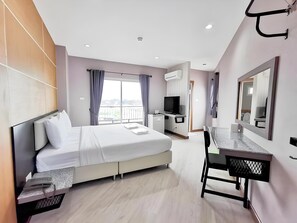 A modern hotel room with a bed, desk, chair, TV, and balcony. - The Y Residence (Chiang Mai)