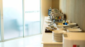 A buffet setup with multiple serving stations, plates, and condiments. - The Y Residence (Chiang Mai)