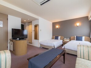 A hotel room with two beds, a TV, a desk, and a sofa. - Nagasaki Orion Hotel (Nagasaki)
