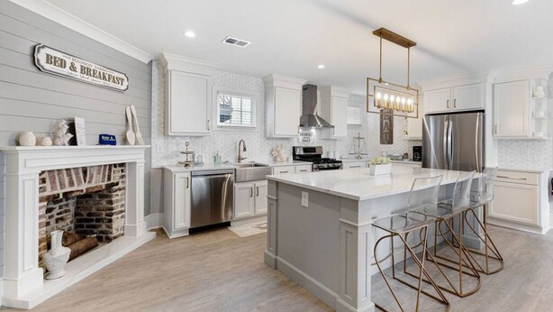 A modern kitchen with a central island, stainless steel appliances, and a fireplace.