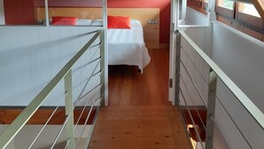 A bedroom with a bunk bed, a wooden ceiling, and a red wall. - RURAL HOUSE AINGERU NATURE AND MOUNTAIN (Aránzazu)