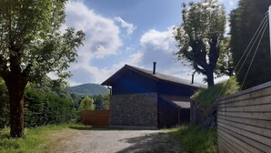 A rustic building with a stone facade and a blue roof, surrounded by trees and a gravel path. - RURAL HOUSE AINGERU NATURE AND MOUNTAIN (Aránzazu)