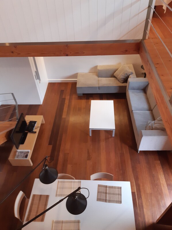 A modern living room with a grey sofa, a white coffee table, and a TV on a wooden stand. - RURAL HOUSE AINGERU NATURE AND MOUNTAIN (Aránzazu)