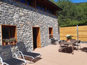 A stone building with a wooden deck, outdoor seating, and potted plants. - RURAL HOUSE AINGERU NATURE AND MOUNTAIN (Aránzazu)