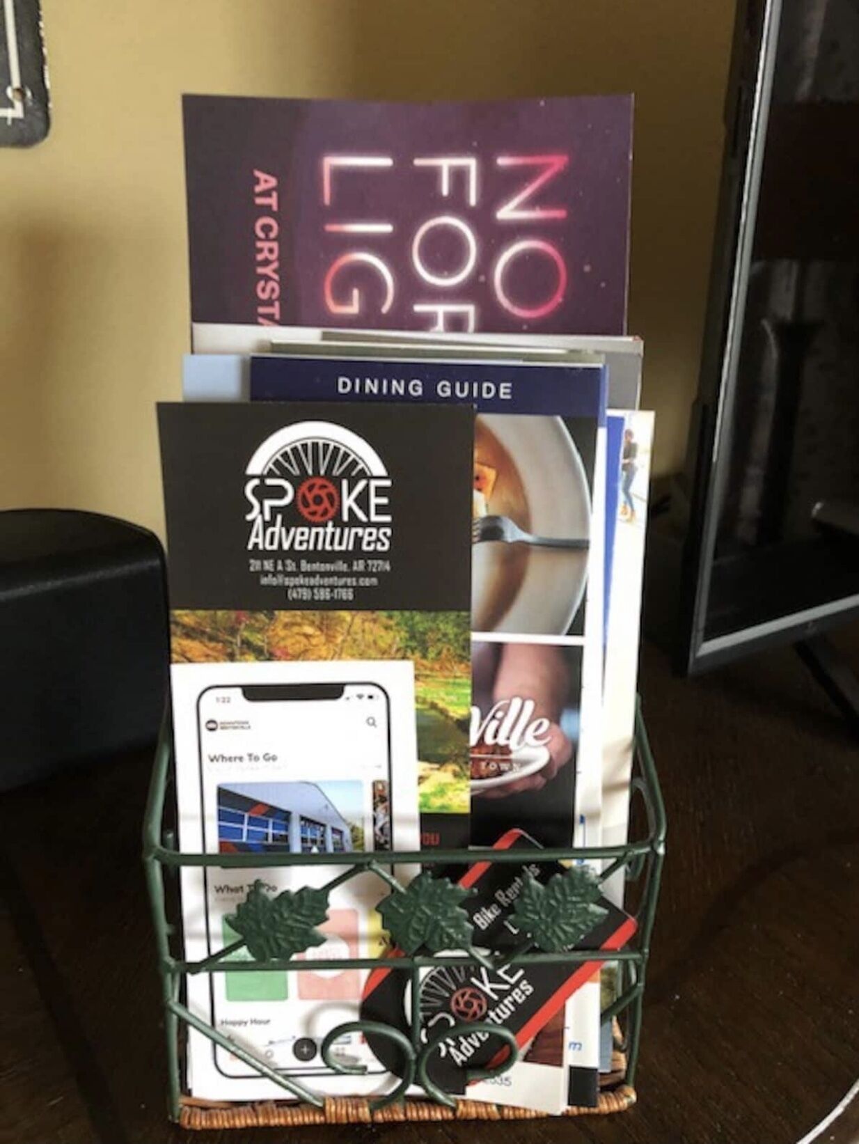 A stack of brochures and a mobile device on a metal stand.