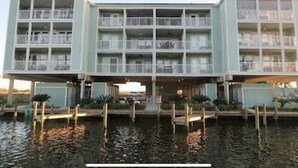 Een hotel met meerdere verdiepingen, balkons, een steiger en uitzicht op het water.