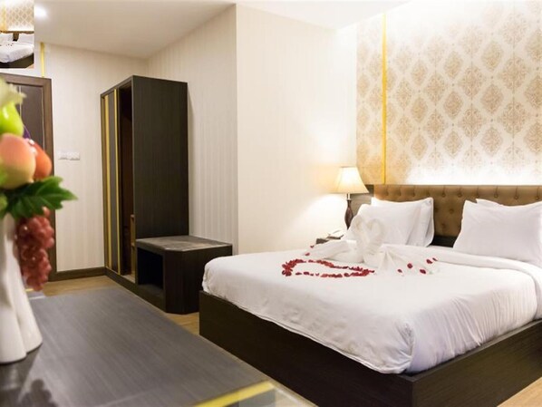 A hotel room with a bed, bedside table, lamp, and a decorative wall.
