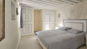 Une chambre à coucher avec un lit, des tables de chevet et une armoire.