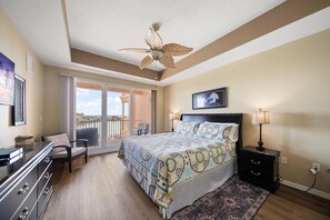 Relax in this serene bedroom with a large bed, ceiling fan, and comfortable seating area.