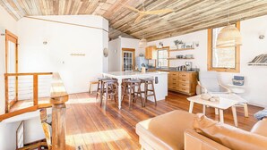 A spacious living area with a wooden ceiling, a kitchen with a large island, and a dining area with bar stools. - The Lake House: Dock|Marine Hammock|Screen Porch (Prospect Hill)