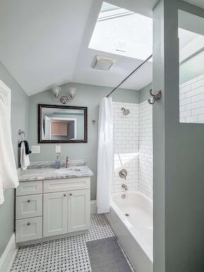 Bathtub, hair dryer, towels, shampoo