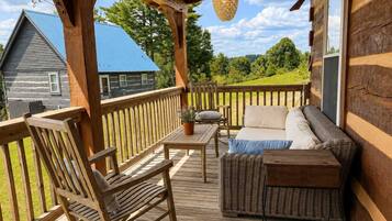 Une terrasse en bois avec un canapé, des chaises et une table.
