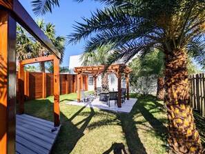 Relax in the serene backyard with a pergola, lawn, and patio seating area.