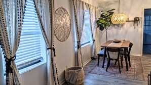 A dining area with a wooden table, chairs, and a hanging light fixture.