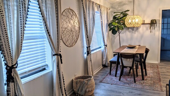 Enjoy meals in this inviting dining area with a wooden table and chairs, a woven basket, and a decorative piece on the wall.
