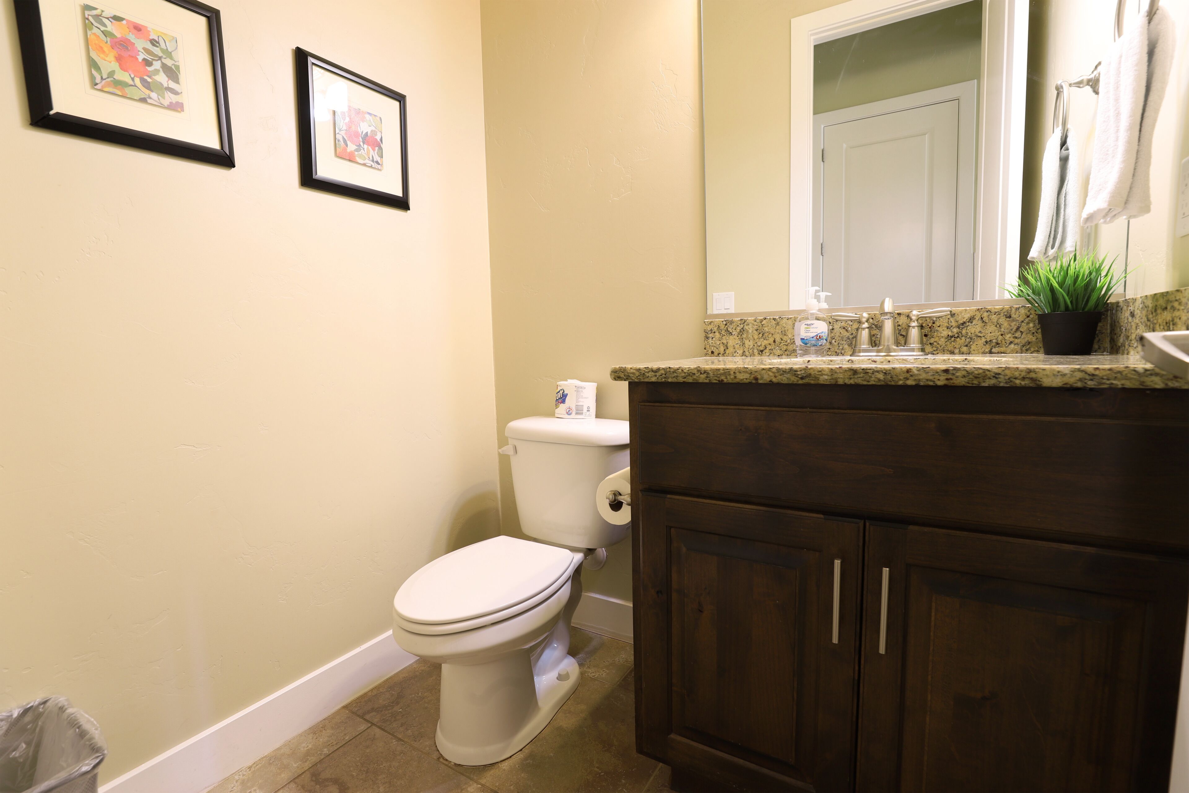 A bathroom with a toilet, vanity, and a mirror.